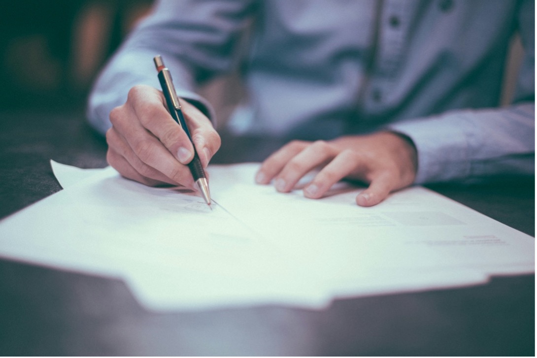 A person reviewing a contract to ensure compliance and streamline procurement process improvement.